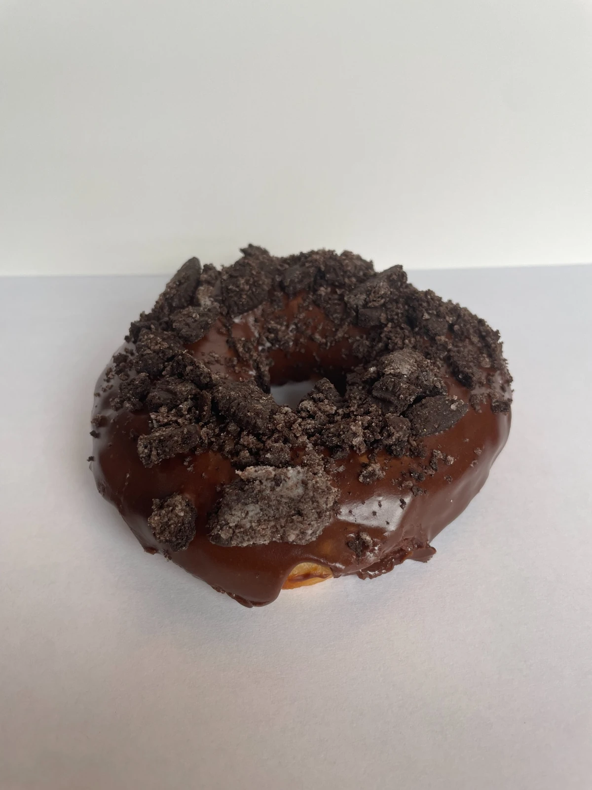 Raised donut with chocolate icing and Oreo topping