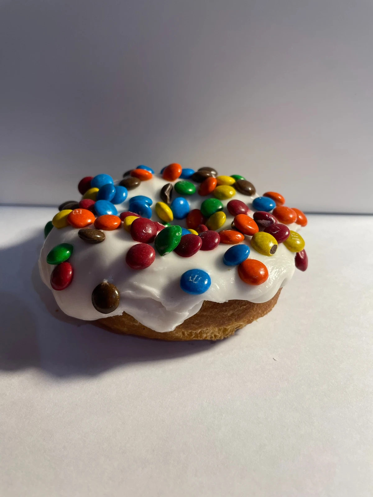 Vanilla cake donut with vanilla icing and colorful candy