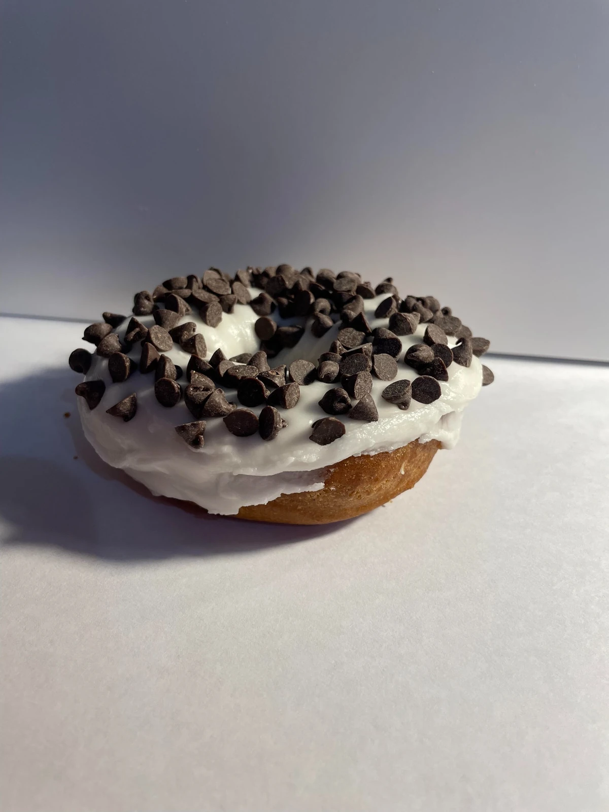 Vanilla cake donut with vanilla icing and chocolate chips