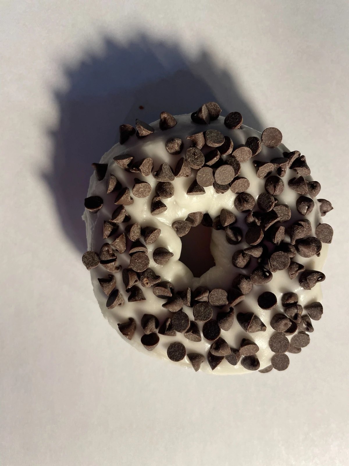 Donut with vanilla icing and chocolate chips
